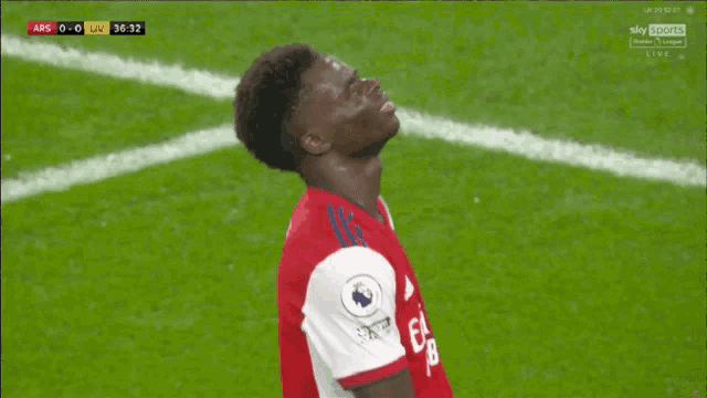 a soccer player wearing a red emirates fly better shirt