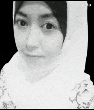 a black and white photo of a woman wearing a white hijab .