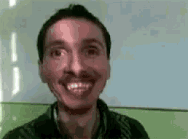 a man with a mustache is smiling while looking at the camera .