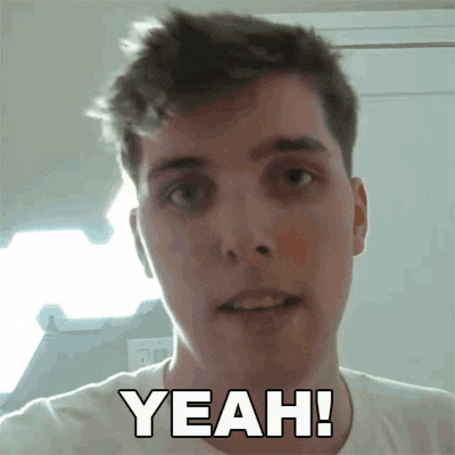 a man in a white shirt is making a funny face and says yeah