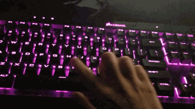 a person is typing on a keyboard that says corsair on it