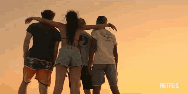 a group of people standing on a beach with their arms around each other and a netflix logo in the background