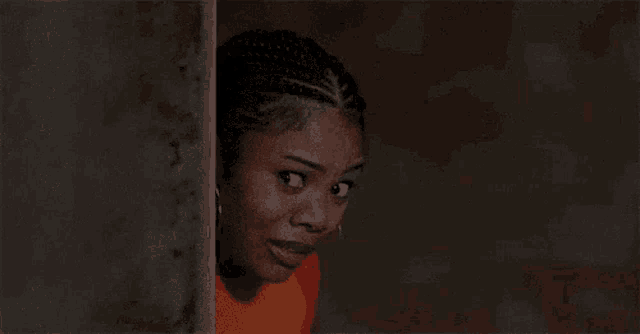 a woman peeking out from behind a wall and smiling