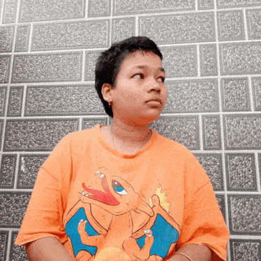 a person wearing an orange shirt with a pokemon on it