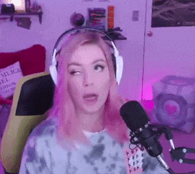 a woman wearing headphones and a tie dye sweater is talking into a microphone .
