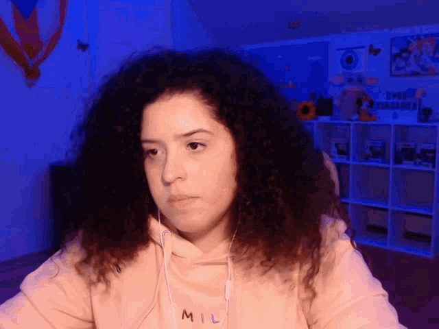 a woman wearing headphones and a hoodie that says mil on it