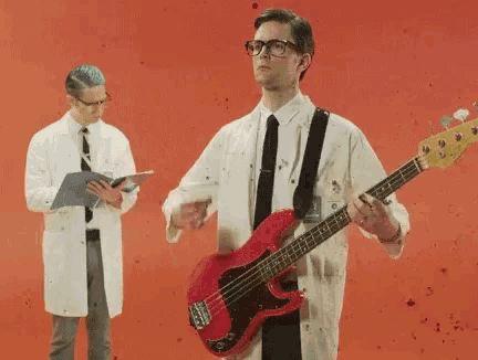 a man in a lab coat is holding a red guitar