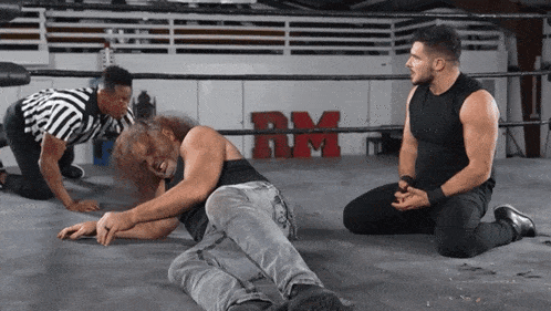 two wrestlers in a ring with the letter rm on the wall