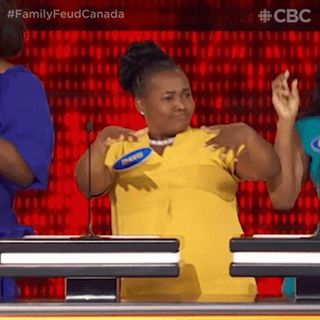 a woman in a yellow shirt is standing in front of a microphone on a stage .