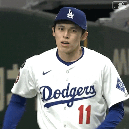 a man wearing a dodgers jersey and a la hat