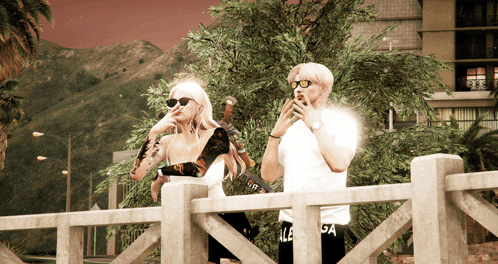 a man and a woman are standing on a bridge and the man is wearing a white shirt that says us