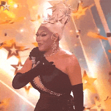 a woman in a black dress is singing into a microphone with stars in the background