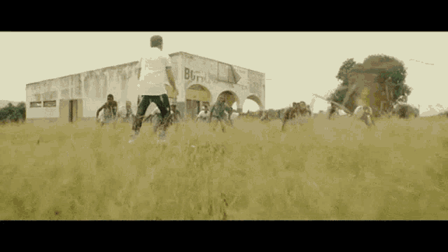 a group of people are playing soccer in a field in front of a building that has the word born on it
