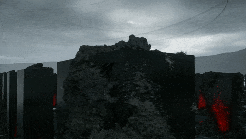 a black and white photo of a rocky area with a few red spots