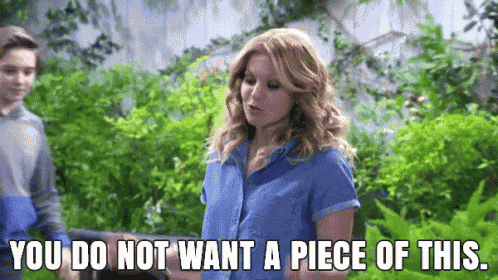 a woman in a blue shirt is standing next to a boy and saying you do not want a piece of this .