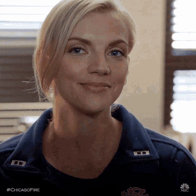 a woman wearing a chicago fire jacket smiles
