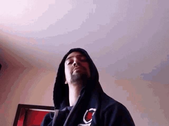 a man with a beard wearing a black hoodie with the letter c on it