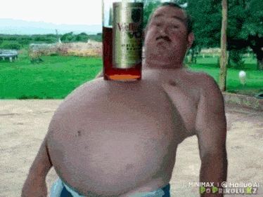a shirtless man holds a bottle of velveeta vodka on his stomach