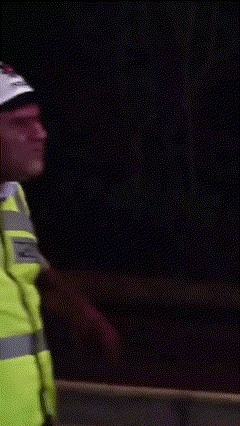 a man wearing a yellow vest and a white hat says " nolmus devrem "