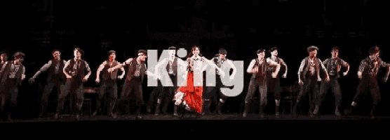 a group of people dancing in front of a sign that says king