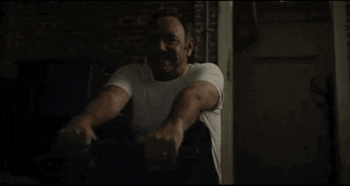 a man in a white shirt is jumping in the air .