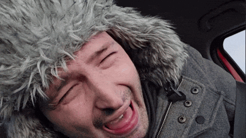 a man wearing a furry hat and a jacket is making a funny face