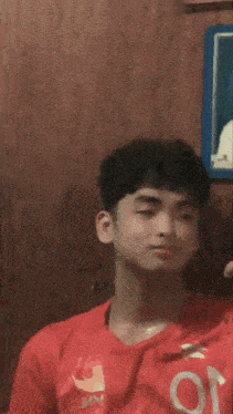 a young boy is taking a selfie in front of a picture of a man in a cap and gown .