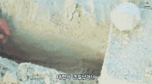 a man and a woman are playing in the sand on the beach .