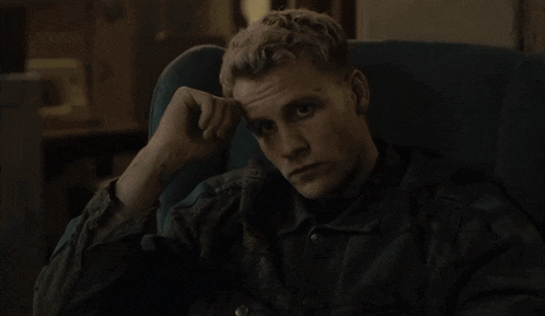 a man in a black jacket is sitting in a chair