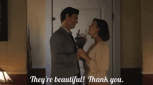 a man holding a bouquet of flowers next to a woman who says " they 're beautiful "