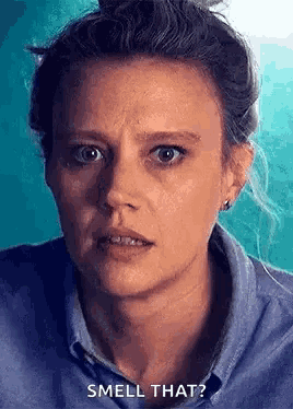 a close up of a woman 's face with the words `` smell that ? ''