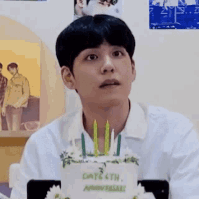 a young man is sitting in front of a cake that says days 6th anniversary .