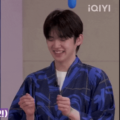 a young man wearing a blue kimono is smiling while holding a blue balloon .