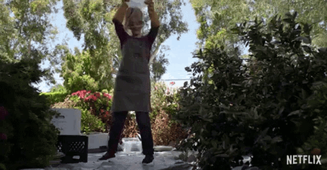 a man wearing an apron and gloves is standing in front of a netflix logo