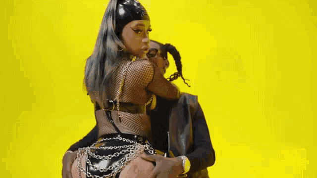 a man is touching the butt of a woman in a fishnet skirt .