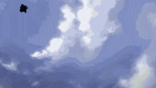 a silhouette of a person is flying through a cloudy sky