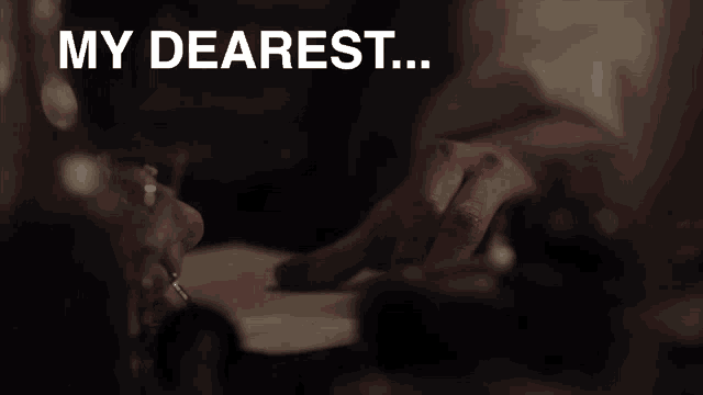 a person writing on a piece of paper with the words " my dearest " written above them