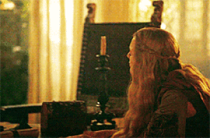 a woman with long blonde hair is sitting at a table with a candle .