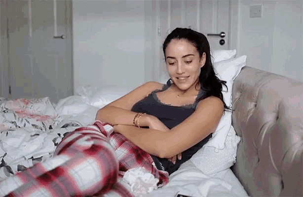 a woman in pajamas is laying on a bed