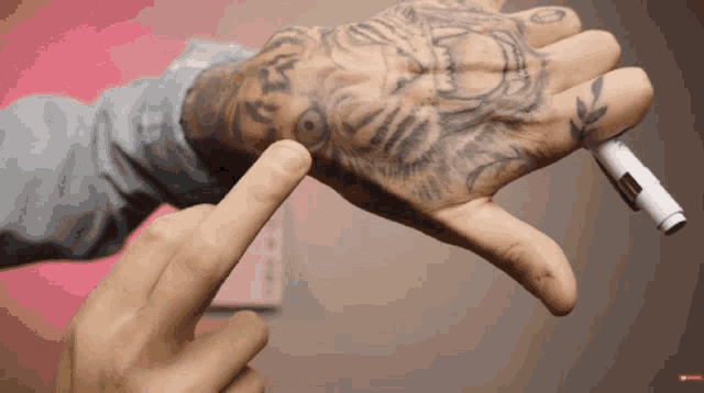 a person with a tattoo on their hand pointing at it