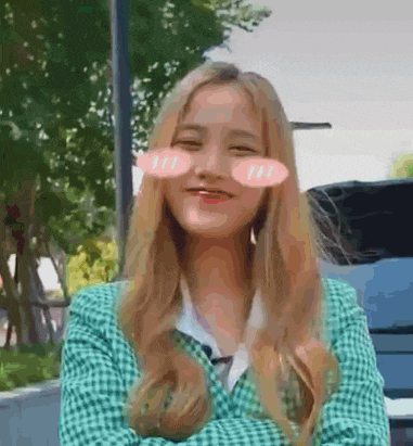 a girl with long blonde hair is wearing a green plaid jacket and smiling .