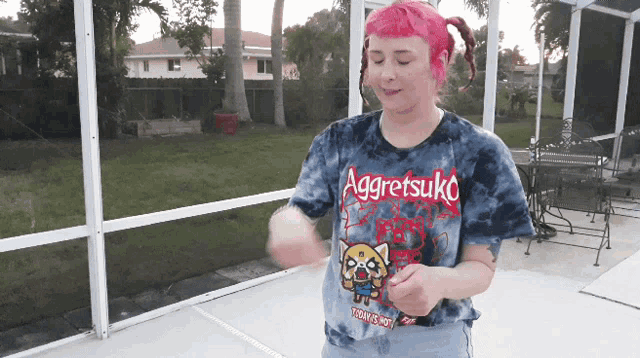 a girl with pink hair is wearing a shirt that says aggretsuko