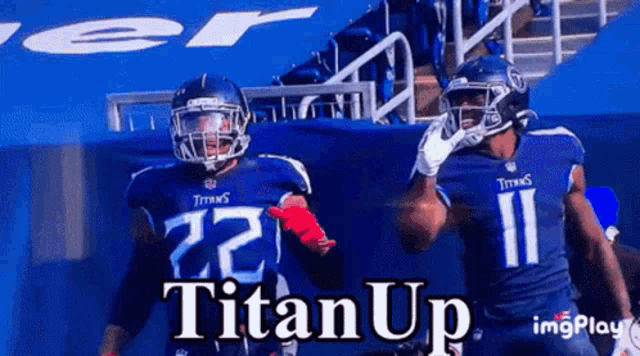 two titans football players are standing in front of a banner that says titanup