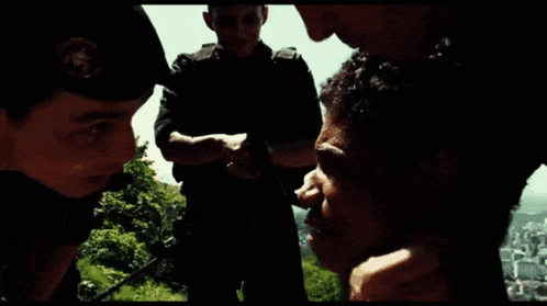 a man is talking to a police officer while another man stands behind him