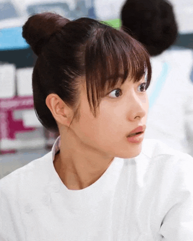 a woman with her hair in a bun looks surprised