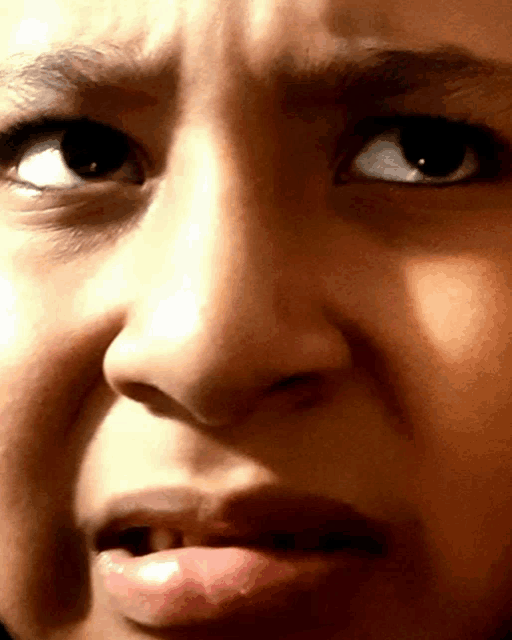 a close up of a child 's face with a surprised look on her face