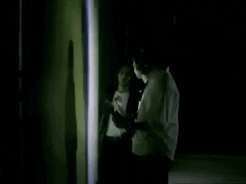 a person is standing in front of a wall with a shadow of a person on it .