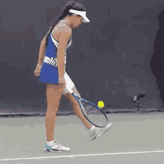 a woman is holding a tennis racquet on a tennis court and playing tennis .