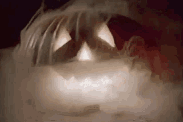 a close up of a pumpkin with smoke coming out of its eyes .