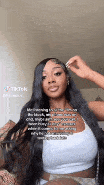 a woman with long black hair is sitting on a couch with a tiktok video .